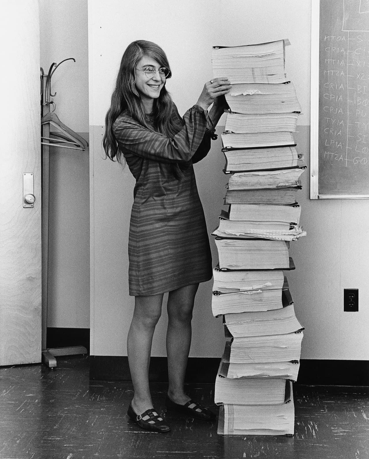 Margaret Hamilton in 1969 with the stack of program listings for the Apollo Guidance Computer. She led the 350-person software team and coined the term 'software engineering'.